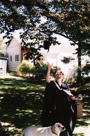 Caroline throwing her mortar board in the air after graduating in the garden at Walton St, 2003. 