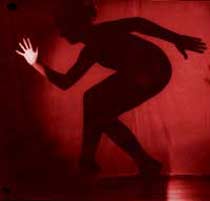 A photograph of a sillouetted Caroline dancing at Woodford House. 